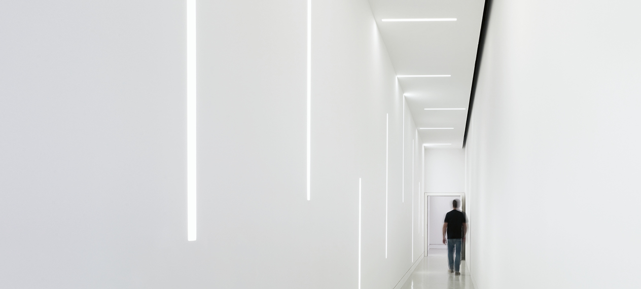 Subtle LED light lines in a hallway. Lighting is mounted on the wall and ceiling and connected by a connector.